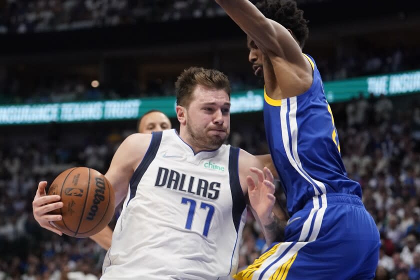 Dallas Mavericks guard Luka Doncic (77) runs into the defense of Golden State Warriors forward Andrew Wiggins during the first half of Game 4 of the NBA basketball playoffs Western Conference finals, Tuesday, May 24, 2022, in Dallas. (AP Photo/Tony Gutierrez)