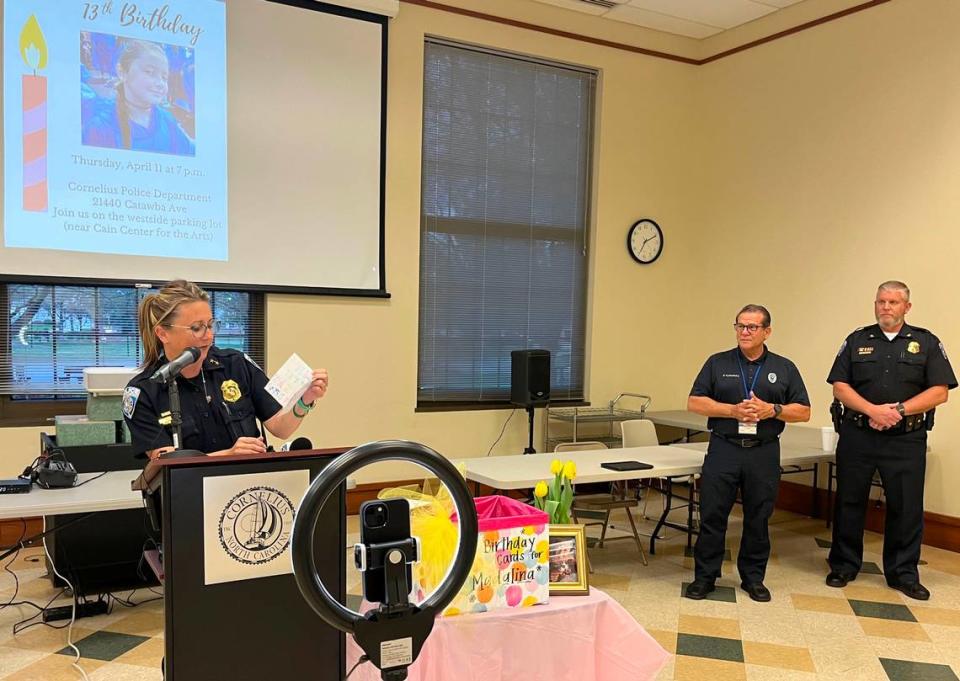 Deputy Chief Jennifer Thompson of the Cornelius police reads birthday cards at a community gathering at town hall to mark the 13th birthday of Madalina Cojocari, who has been missing since November 2022. Behind her at the April 11, 2024 event are police Chaplain Paul Turbedsky, left, and Chief David Baucom