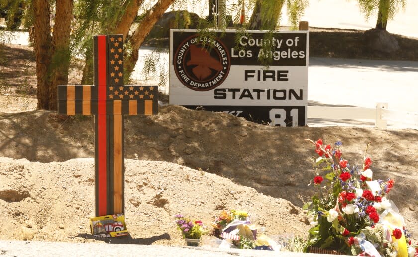 AGUA DULCE, CA - JUNE 04: A memorial features a cross made of wood along with flowers outside Los Angeles County Fire Dept. Station 81 at 8710 Sierra Hwy in Agua Dulce where LA County Firefighter specialist Tory Carlon, 44, was killed in a shooting last Tuesday. The twenty-year veteran of the department was killed by fellow off-duty firefighter Jonathan Tatone, who opened fire wounding a Captain as well, then fled to his home in nearby Acton, barricaded himself inside, and set the house on fire before he was found dead. LA County Fire Station 81 on Friday, June 4, 2021 in Agua Dulce, CA. (Al Seib / Los Angeles Times).