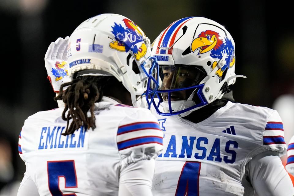 Kansas Jayhawks running back Devin Neal (4), right, pats Kansas Jayhawks wide receiver Doug Emilien (5)â€™s helmet after Neal (4) scores a touchdown during the NCAA college football game between the Cincinnati Bearcats and Kansas Jayhawks on Saturday, Nov. 25, 2023, at Nippert Stadium in Cincinnati. This is the Bearcatsâ€™ last game of the season, as well as their Senior Night Saturday.