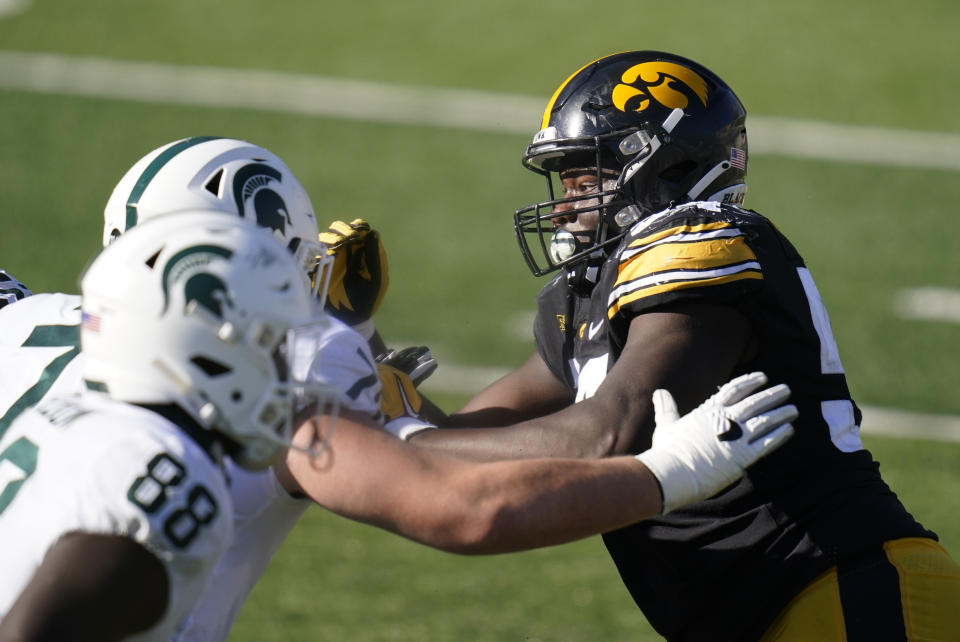 Iowa defensive tackle Daviyon Nixon, right, rushes up field during the second half of an NCAA college football game against Michigan State, Saturday, Nov. 7, 2020, in Iowa City, Iowa. Nixon was selected to The Associated Press All-America first-team defense, Monday, Dec. 28, 2020. (AP Photo/Charlie Neibergall)