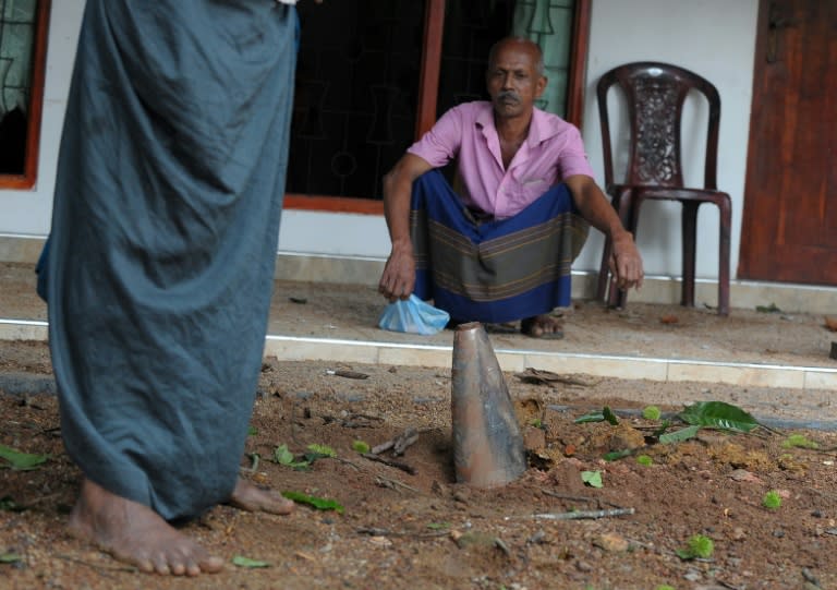 A mortar shell is seen lodged in front of a house at Salawa on the edge of the Sri Lankan capital Colombo on June 6, 2016, hours after explosion at an ammunition depot at the neighbouring military complex