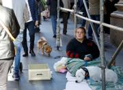 A woman begs on the street in Naples