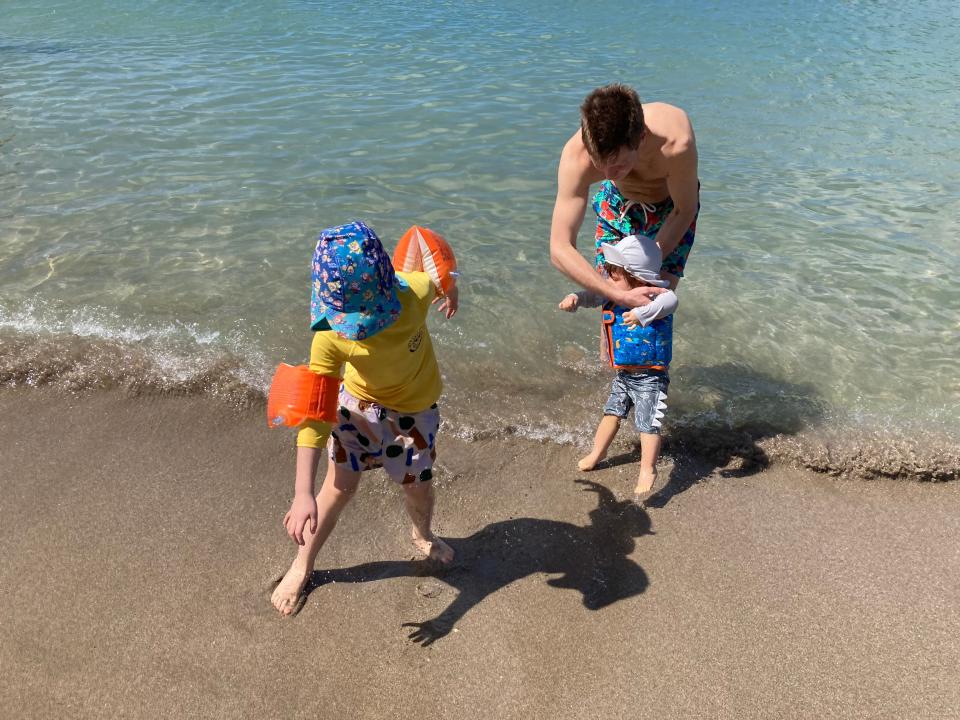 MaryLou Costa's husband with their two kids by the ocean.