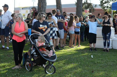 People during a vigil held at the Texas First Bank after a shooting left several people dead at Santa Fe High School in Santa Fe, Texas, U.S., May 18, 2018. REUTERS/Trish Badger