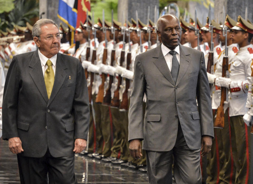 CAPTION CORRECTS AGE - FILE - Cuba's President Raul Castro, left, and Angola's President Jose Eduardo dos Santos review an honor guard during a welcoming ceremony at the Revolution Palace in Havana, Cuba, Wednesday, June 18, 2014. Former Angolan president Jose Eduardo dos Santos has died in a clinic in Barcelona, Spain after an illness, the Angolan government said. He was 79 years old and died following a long illness, the government said Friday, July 8, 2022 in an announcement on its Facebook page. (Adalberto Roque/Pool Photo via AP, File)