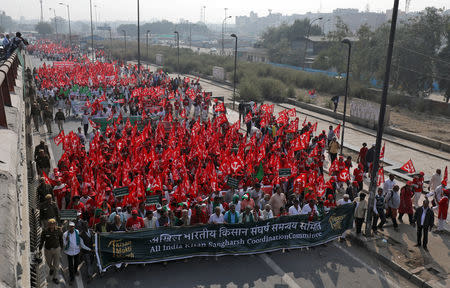 Farmers wave flags and shout slogans as they march towards Ramlila Ground during a protest rally demanding a complete waiver of debt and fixed assurances on crop prices, in New Delhi, November 29, 2018. REUTERS/Anushree Fadnavis