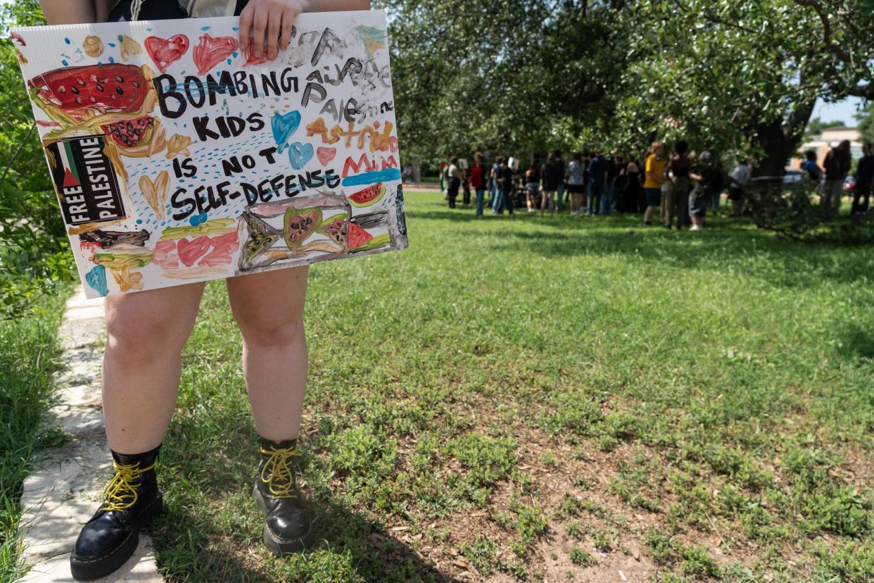 Pia Ibsen holds a sign as students participate in a walk-out during a pro-Palestenian protest at McCallum High School Monday, April 29, 2024.
