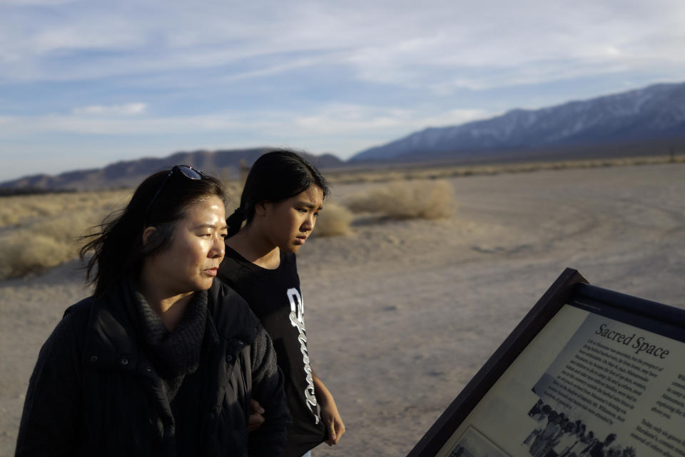 Lori Matsumura, left, and her niece, Lilah Matsumura, view a sign at Manzanar National Historic Site near Independence, Calif., Monday, Feb. 17, 2020. The sign mentions that Lori Matsumura's grandfather, Giichi Matsumura, a prisoner at the internment camp, died while exploring the nearby high Sierra in 1945. Hikers discovered his mountainside grave and unearthed the skeleton in 2019, leading authorities to retrieve the bones and return them to the Matsumura family. (AP Photo/Brian Melley)