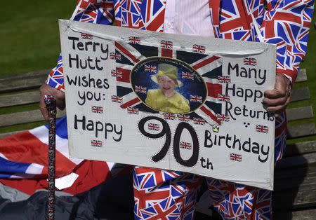 Royal fan Terry Hutt holds a placard as he stands outside of Windsor Castle in Windsor Britain April 20, 2016. Britain's Queen Elizabeth celebrates her 90th birthday in Windsor on April 21. REUTERS/Toby Melville