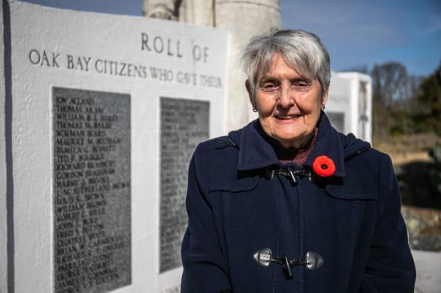 Anne Underhill stands in front of a memorial listing all the citizens of Oak Bay, B.C., who died in the Second World War, including her father, Robert Coventry. He's set to be memorialized with a plaque near the place where he died in England in 1940.