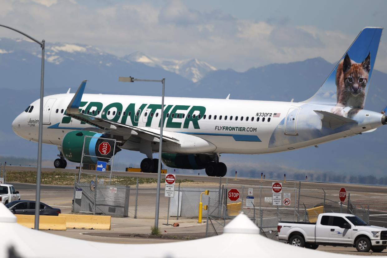 A Frontier Airlines jet heads down a runway for take off from Denver International Airport.