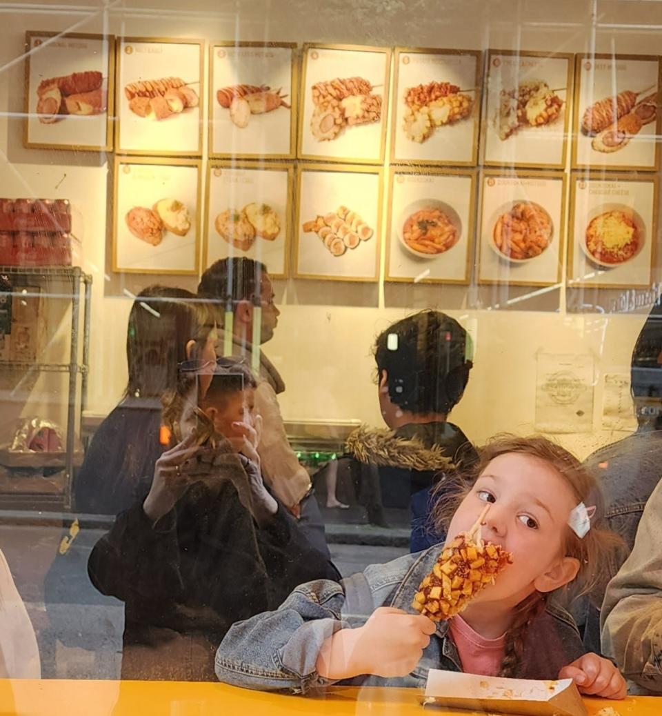 In Soho, we saw Bunsik, a Korean street food spot that sells corn dogs and sausages on a stick. It had a line out the door and an enthusiastic eater enjoying one at the counter.