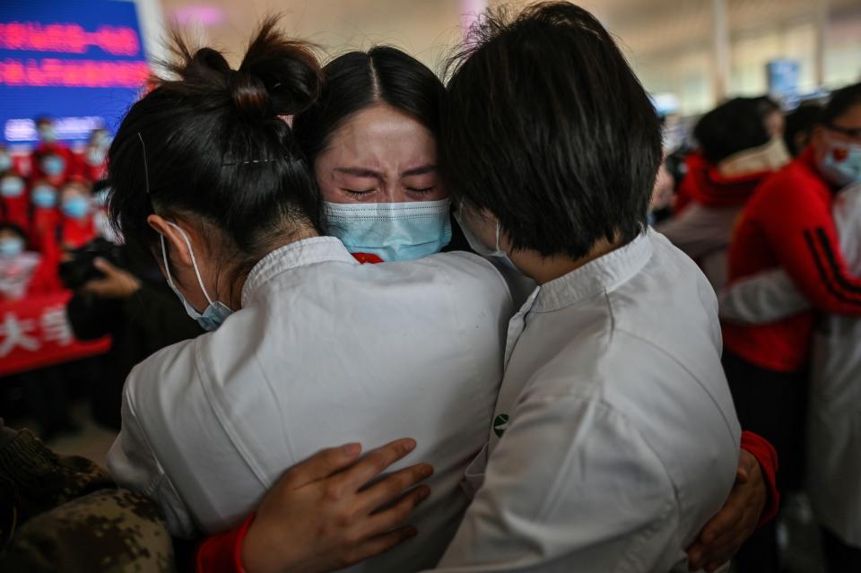 A medical staff member from Jilin Province (centre) cries while hugging nurses from Wuhan during a re-opening ceremony at Wuhan Tianhe International Airport.