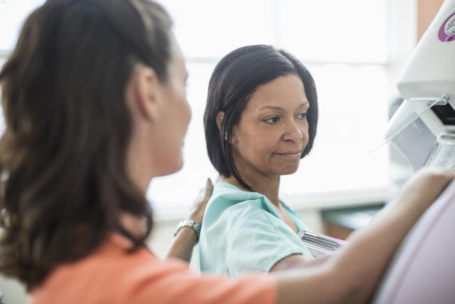 A nurse prepares a patient for mammography.