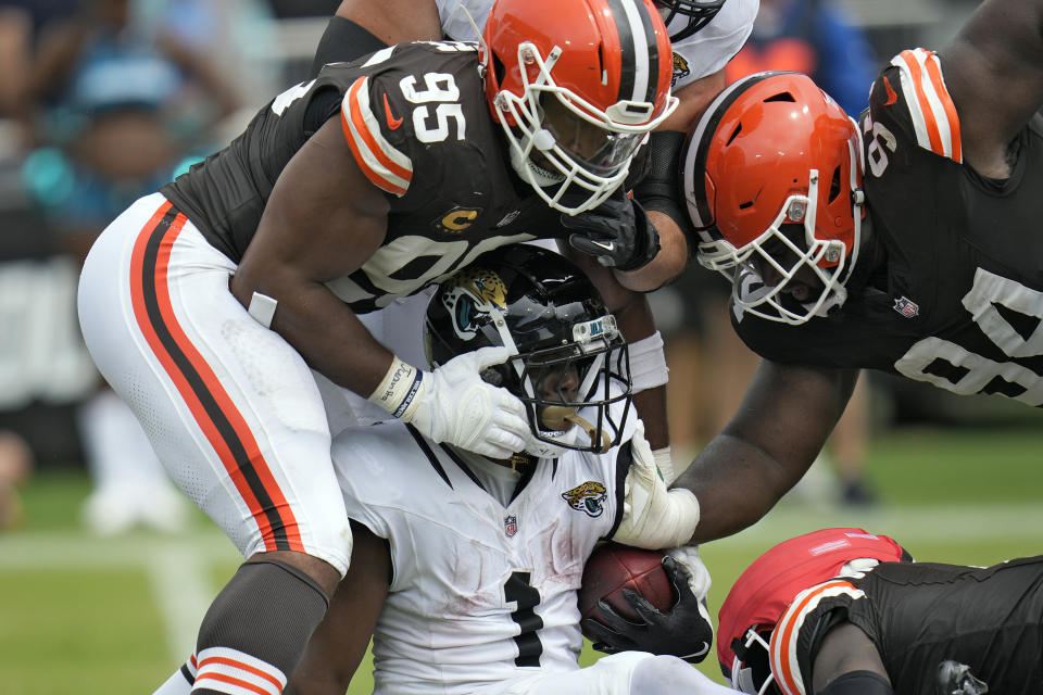 Cleveland Browns defensive end Myles Garrett (95) and defensive tackle Dalvin Tomlinson (94) team up to stop Jacksonville Jaguars running back Travis Etienne Jr. (1) during the second half of an NFL football game Sunday, Sept. 15, 2024, in Jacksonville, Fla. (AP Photo/John Raoux)