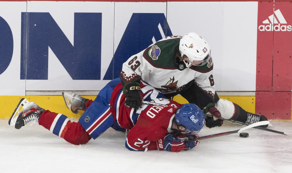 Montreal Canadiens' Cole Caufield (22) and Arizona Coyotes' Matias Maccelli (63) compete for the puck during the second period of an NHL hockey game Tuesday, Feb. 27, 2024, in Montreal. (Christinne Muschi/The Canadian Press via AP)