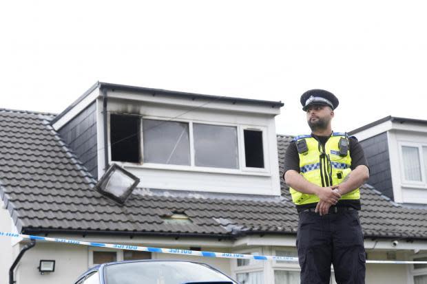 Bradford Telegraph and Argus: A police officer stands outside the house on Kingsdale Drive.