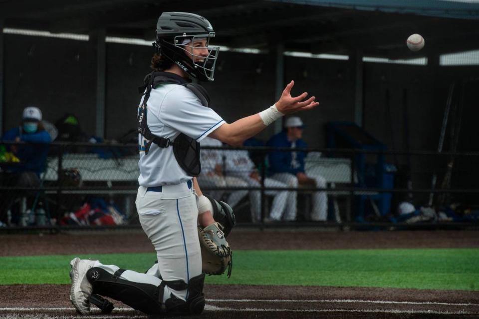 Tahoma High School catcher Carson Ohland smiles as he catches a ball during the Class 4A/3A North Puget Sound League baseball championship game on Saturday, May 22, 2021 in Maple Valley, Wash. Tahoma topped Kentlake, 5-1.