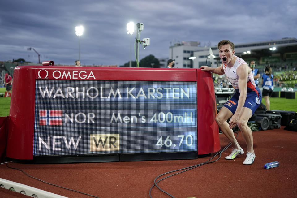 El noruego Karsten Warholm festeja frente a un marcador electrónico que muestra su récord mundial en los 400 metros con vallas, el jueves 1 de julio de 2021, en una competición de la Liga Diamante en Oslo (Fredrik Hagen, NTB via AP)