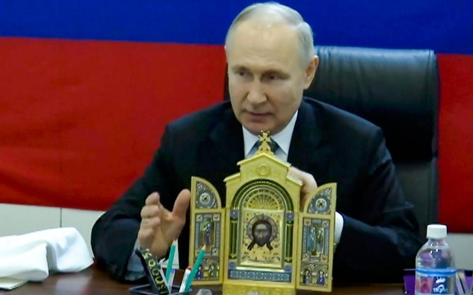 Vladimir Putin shows an icon prior to present at one of headquarters of the Russian troops at an undisclosed location - Pool Sputnik Kremlin/Pool Photo via AP