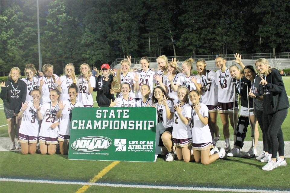 Members of the Portsmouth High School girls lacrosse team hold up five fingers to symbolize their fifth straight Division II title Wednesday night in Nashua.