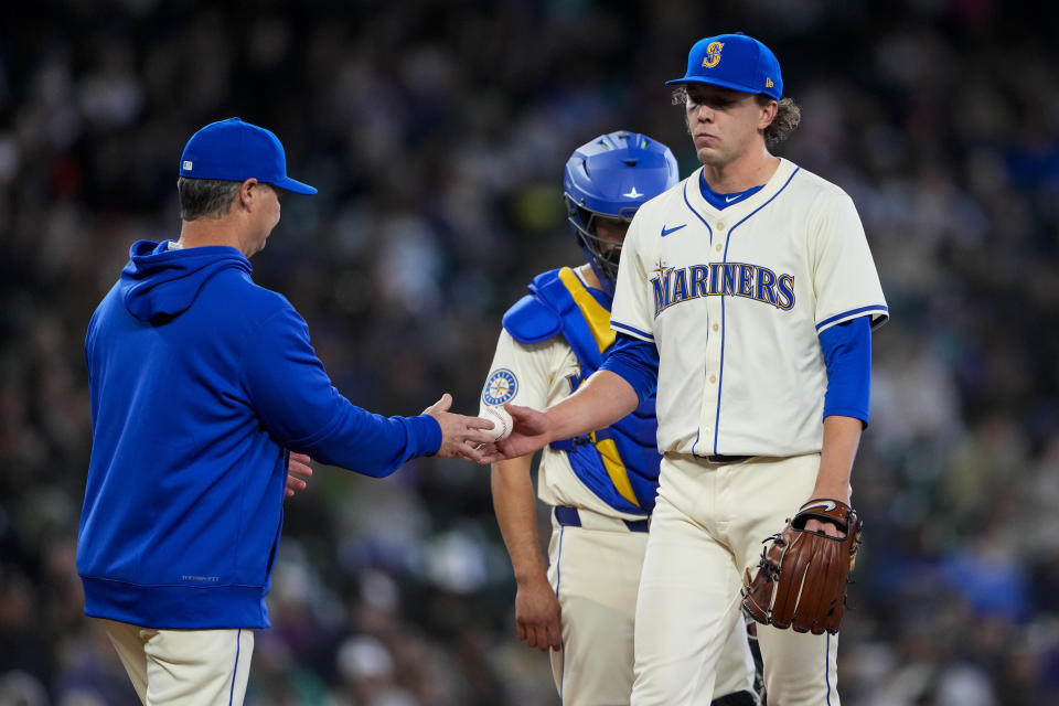 Seattle Mariners manager Scott Servais, left, takes the ball from starting pitcher Logan Gilbert as he is relieved from the game against the Arizona Diamondbacks during the seventh inning of a baseball game Sunday, April 28, 2024, in Seattle. (AP Photo/Lindsey Wasson)