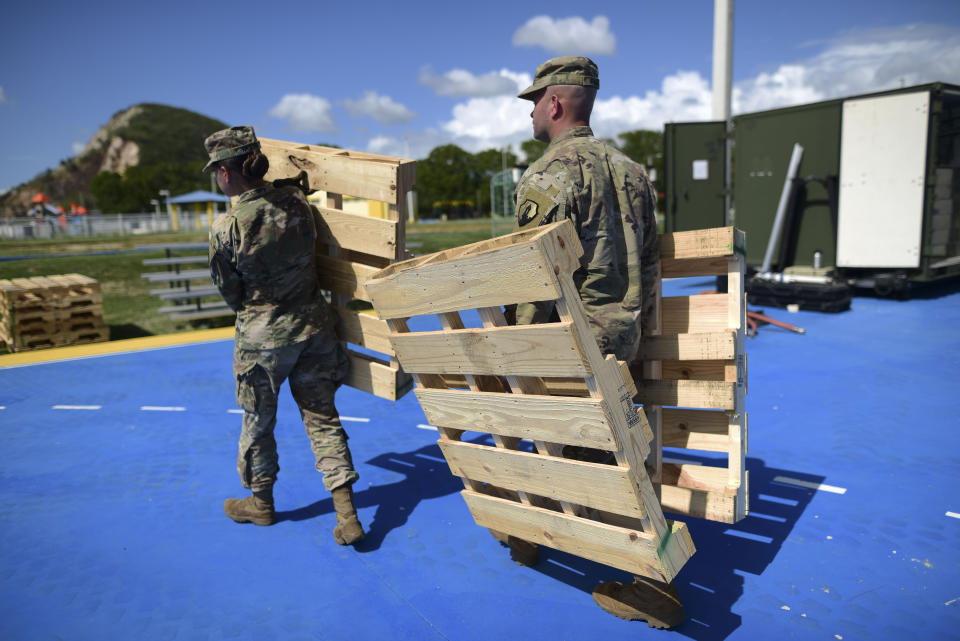 Members of the US army reserve set up portable showers in a tent city for hundreds of people displaced by earthquakes in Guanica, Puerto Rico, Tuesday, Jan. 14, 2020. A 6.4 magnitude quake that toppled or damaged hundreds of homes in southwestern Puerto Rico is raising concerns about where displaced families will live, while the island still struggles to rebuild from Hurricane Maria two years ago. (AP Photo/Carlos Giusti)