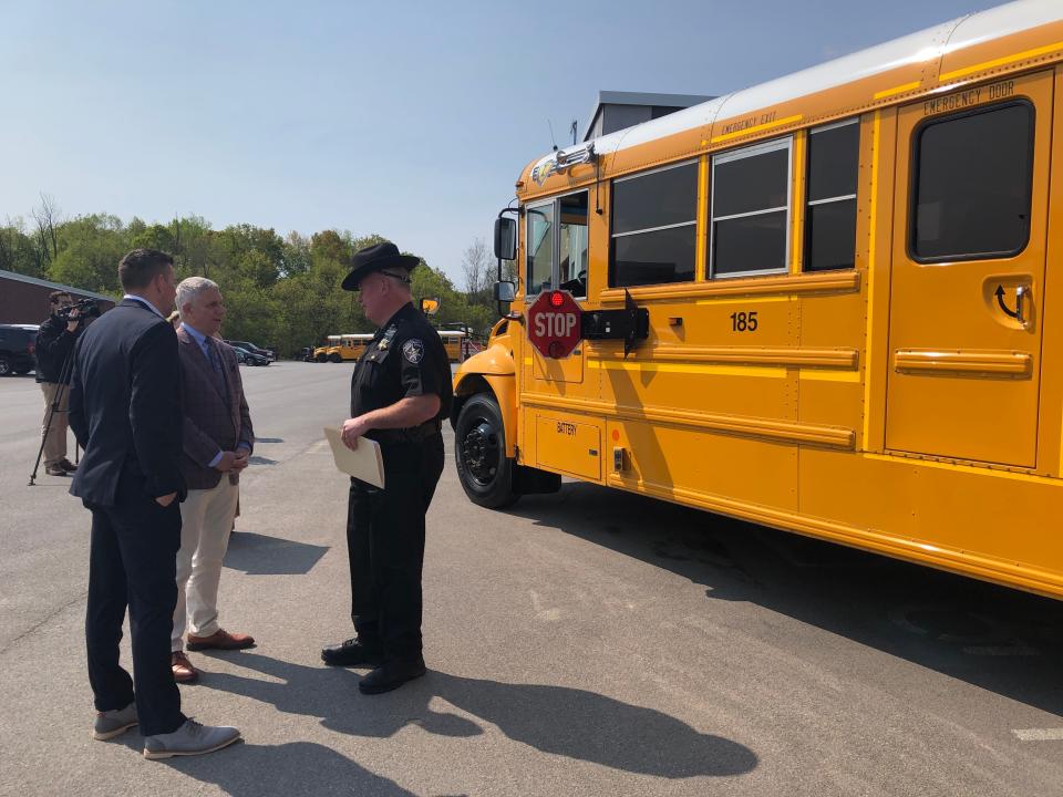 Oneida County Executive Anthony Picente Jr., center, and  Oneida County Sheriff Rob Maciol, right, chat after a press conference at the Sauquoit Central Valley School District bus garage to announce that buses in several local school districts are now equipped with cameras that will take video of vehicles that pass stopped school buses. The vehicles' owners will then receive a notice of a civil fine in the mail.
