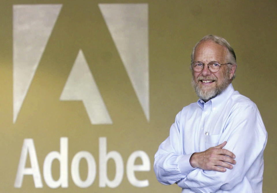 FILE - Adobe co-founder John Warnock smiles in the lobby at Adobe headquarters in San Jose, Calif., on May 9, 2001. Warnock, the inventor of the PDF and Adobe Systems co-founder died Saturday, Aug. 19, 2023, the software company said. (AP Photo/Paul Sakuma, File)