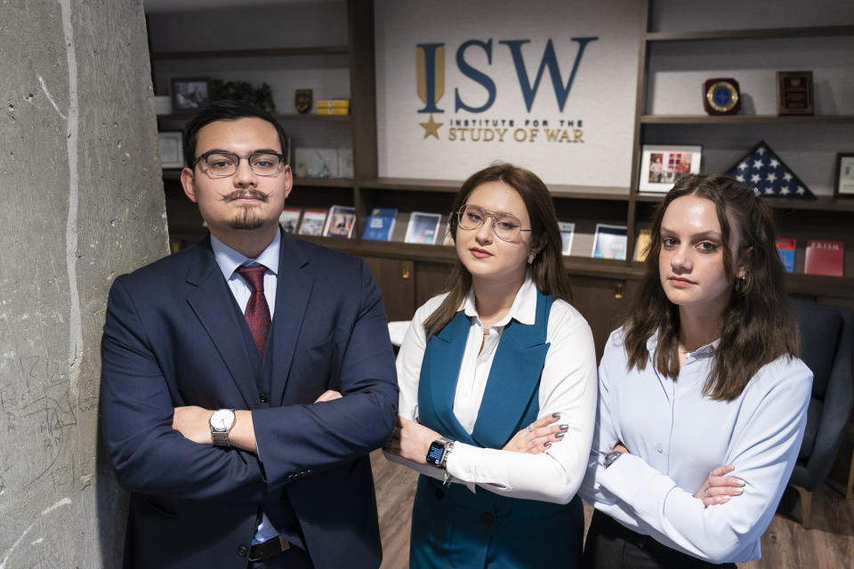 George Barros, left, a Geospatial Analyst on the Russia Team, Kateryna Stepanenko, a Russia Analyst, and Karolina Hird, a Russia Analyst, pose for a photograph at the Institute for the Study of War, Wednesday, Jan. 11, 2023, in Washington. (AP Photo/Alex Brandon)