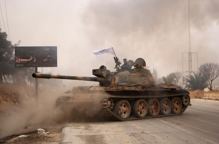 Rebel fighters from the Jaish al-Fatah (or Army of Conquest) brigades manoeuver a T-55 tank as they take part in a major assault on Syrian government forces west of Aleppo city