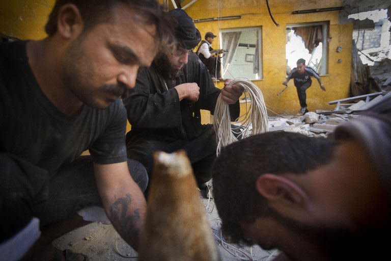 Syrian rebel fighters undertake an operation to plant a bomb inside a building under government forces control in the northern city of Aleppo on May 27, 2013