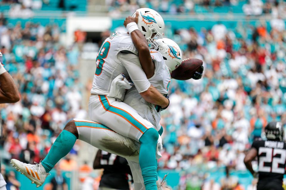 Mike Gesicki (88) celebrates a touchdown with QB Tua Tagovailoa during a 2021 game against Atlanta.