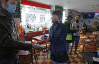 A man has his coronavirus vaccine pass checked, at a restaurant in Lille, northern France, Monday, Jan. 24, 2022. Unvaccinated people are no longer allowed in France's restaurants, bars, tourist sites and sports venues, as a new law came into effect Monday requiring a "vaccine pass" that is central to the government's anti-virus strategy. (AP Photo/Michel Spingler)