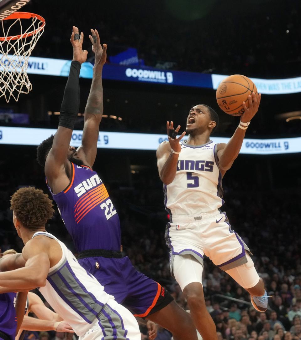 11 mars 2023 ;  Phoenix, Arizona, États-Unis ;  Sacramento Kings guard De'Aaron Fox (5) tire la balle sur le centre des Phoenix Suns Deandre Ayton (22) au Footprint Center. 