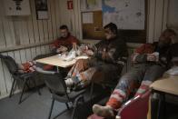 Coal miners rest during a shift in the break room of the Gruve 7 coal mine in Adventdalen, Norway, Monday, Jan. 9, 2023. The mine is scheduled to be shut down in two years, cutting carbon dioxide emissions in this fragile, rapidly changing environment, but also erasing the identity of a century-old mining community that fills many with deep pride even as the primary activities shift to science and tourism. (AP Photo/Daniel Cole)