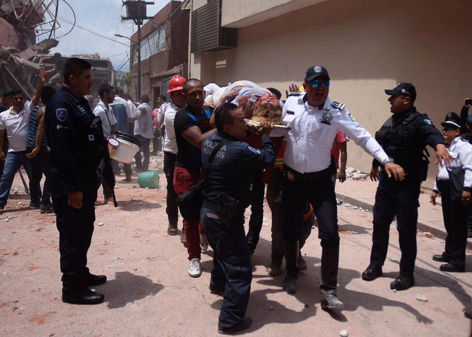 <p>MEX60. CUERNAVACA (MÉXICO), 19/09/2017.- Rescatistas ayudan a una mujer que se encontraba entre los escombros de los edificios colapsados en Cuernavaca, Morelos (México) hoy, martes 19 de septiembre de 2017, tras un sismo de magnitud 7,1 en la escala de Richter, que sacudió fuertemente la capital mexicana y causó escenas de pánico justo cuanto se cumplen 32 años de poderoso terremoto que provocó miles de muertes. EFE/Tony Rivera </p>
