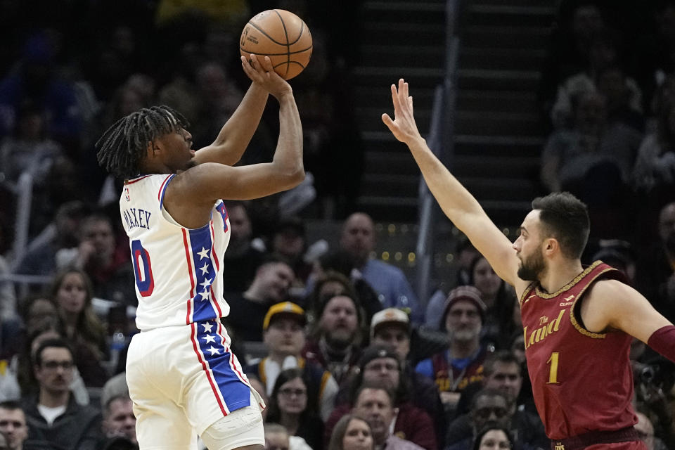 Philadelphia 76ers guard Tyrese Maxey (0) looks to shoot over Cleveland Cavaliers guard Max Strus, right, in the second half of an NBA basketball game, Monday, Feb. 12, 2024, in Cleveland. (AP Photo/Sue Ogrocki)