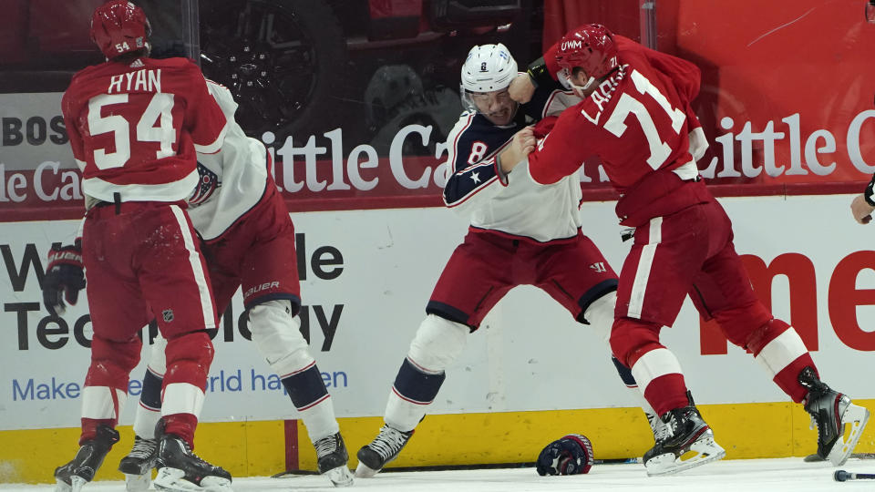 Detroit Red Wings center Dylan Larkin (71) punches Columbus Blue Jackets defenseman Zach Werenski (8) as Bobby Ryan (54) fights Columbus Blue Jackets right wing Oliver Bjorkstrand (28) in the third period of an NHL hockey game Monday, Jan. 18, 2021, in Detroit. (AP Photo/Paul Sancya)