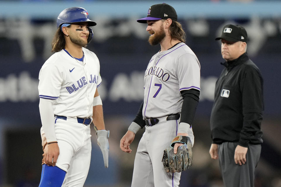 Toronto Blue Jays' Bo Bichette, left, and Colorado Rockies second baseman Brendan Rodgers (7) meet after Bichette stole second during first-inning baseball game action in Toronto, Friday, April 12, 2024. (Frank Gunn/The Canadian Press via AP)