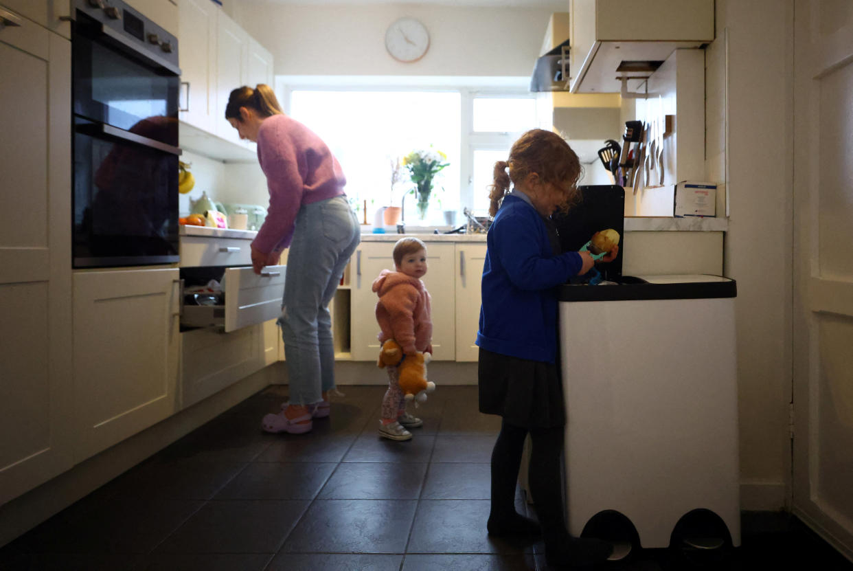 Parents  Lola Sharples, 4, peels a potato as she helps her mother, Louise, prepare dinner in the kitchen of their home in Clitheroe, East Lancashire, Britain, March 1, 2023. REUTERS/Hannah McKay