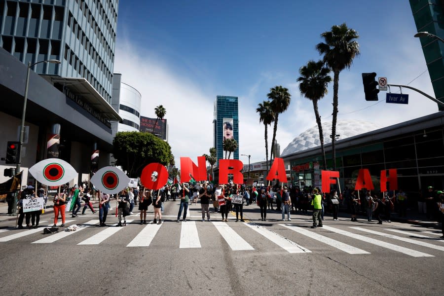 Protesters line up holding letters and symbols reading “Eyes on Rafah,” during a demonstration in support of Palestinians calling for a ceasefire in Gaza as the 96th Academy Awards Oscars ceremony is held nearby, Sunday, March 10, 2024, in the Hollywood section of Los Angeles. (AP Photo/Etienne Laurent)