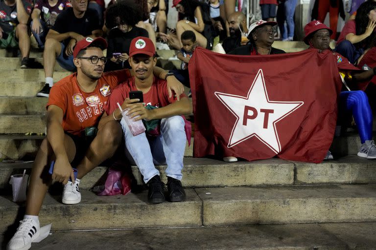 Seguidores del expresidente brasileño Luiz Ignácio "Lula" da Silva, quien vuelve a postularse para presidente, escuchan los resultados parciales luego del cierre de las urnas para las elecciones generales en Río de Janeiro, Brasil, el domingo 2 de octubre de 2022. (Foto AP/Silvia Izquierdo)