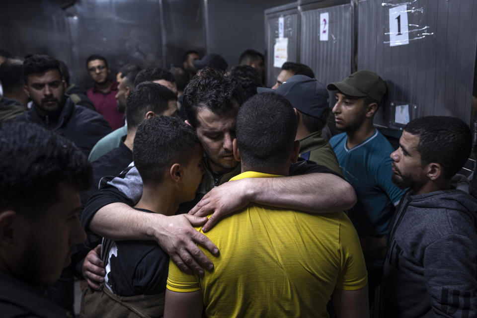 Mourners comfort each other in the morgue of Al-Shifa Hospital after Israeli airstrikes killed a dozen Palestinians in Gaza City, Tuesday, May 9, 2023. The Israeli military says it has killed three senior commanders of the militant Islamic Jihad group in targeted airstrikes. Palestinian health officials said 12 people were killed in total in Tuesday's attacks, including the commanders, their wives, several of their children and others nearby. (AP Photo/Fatima Shbair)