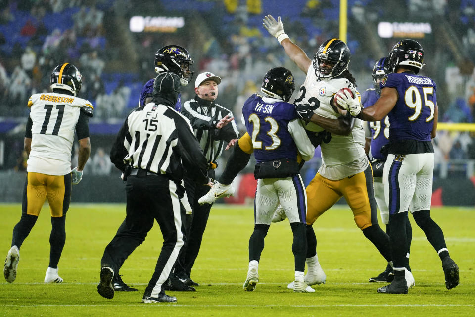 Officials try to break separate Baltimore Ravens cornerback Rock Ya-Sin (23) and Pittsburgh Steelers running back Najee Harris (22) during the second half of an NFL football game, Saturday, Jan. 6, 2024 in Baltimore. (AP Photo/Matt Rourke)