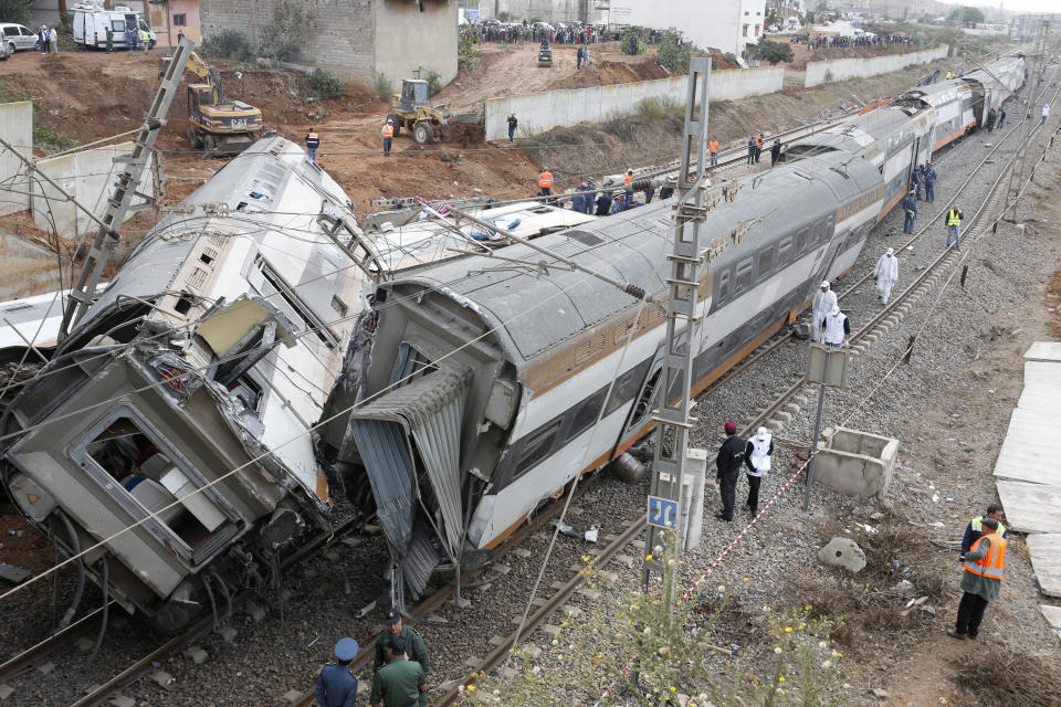 People gather after a train derailed Tuesday Oct.16, 2018 near Sidi Bouknadel, Morocco. A shuttle train linking the Moroccan capital Rabat to a town further north on the Atlantic coast derailed Tuesday, killing several people and injuring dozens, Moroccan authorities and the state news agency said. (AP Photo/Abdeljalil Bounhar)