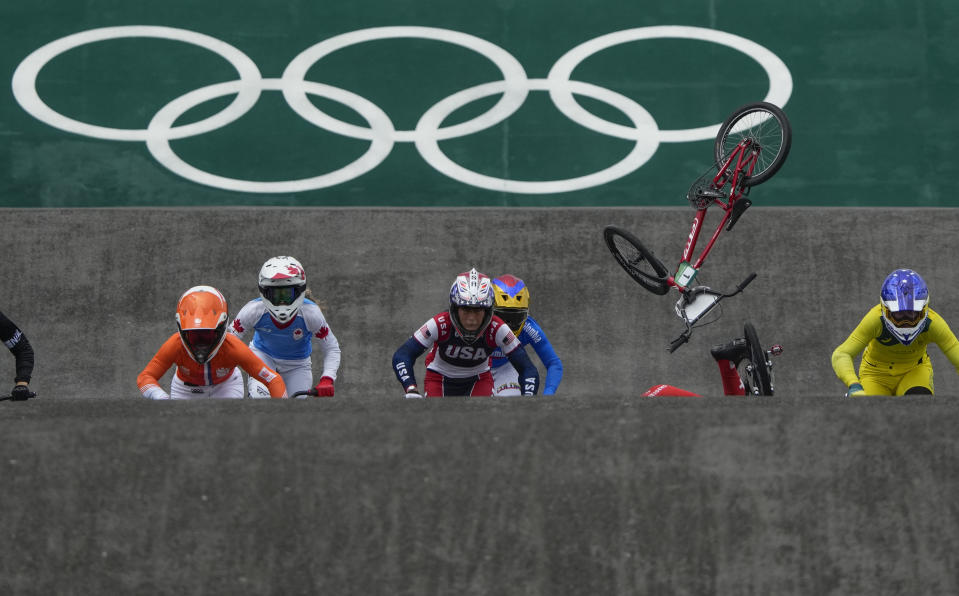 FILE - Felicia Stancil, of the United States, center, looks ahead as the bike of teammate Alise Willoughby flies in the air after she crashed in the BMX Racing semifinals at the 2020 Summer Olympics, Friday, July 30, 2021, in Tokyo, Japan. BMX racing has been described as NASCAR on two wheels, only stock car racing is probably a whole lot safer.(AP Photo/Ben Curtis, File)
