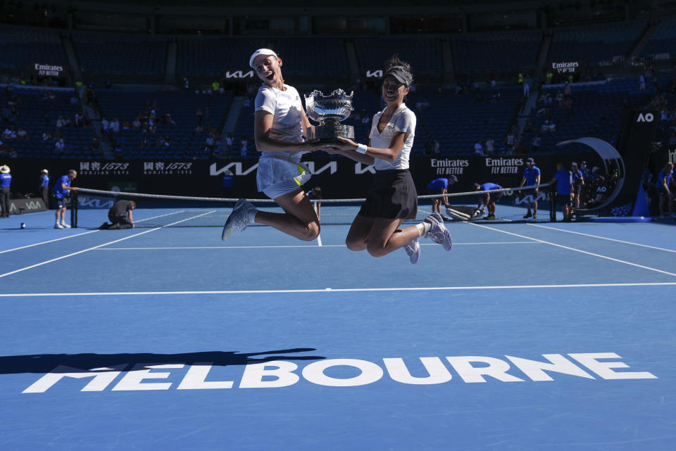 Hsieh Su-Wei, right, of Taiwan and Elise Mertens of Belgium jump as they pose with their trophy after defeating Jelena Ostapenko of Latvia and Lyudmyla Kichenok of Ukraine in the women's doubles final at the Australian Open tennis championships at Melbourne Park, in Melbourne, Australia, Sunday, Jan. 28, 2024. (AP Photo/Andy Wong)