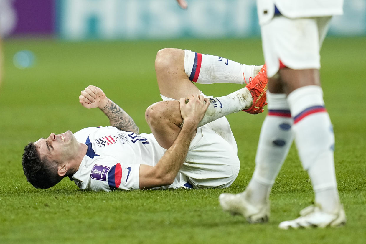 Christian Pulisic of the United States grimaces on the ground during the World Cup round of 16 soccer match between the Netherlands and the United States, at the Khalifa International Stadium in Doha, Qatar, Saturday, Dec. 3, 2022. (AP Photo/Ebrahim Noroozi)